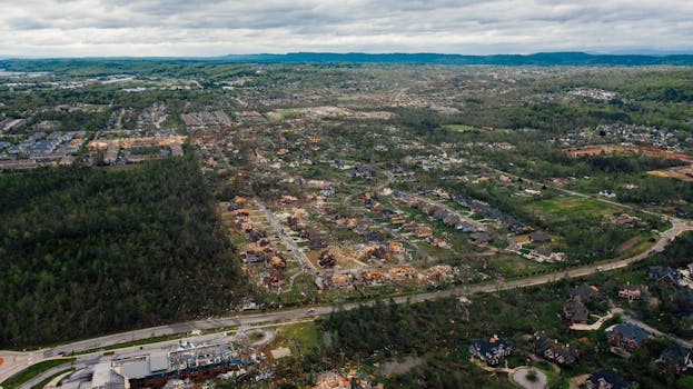 Aerial view of dramatic consequences of thunderstorm on town suburban district including damaged cottages and uprooted trees