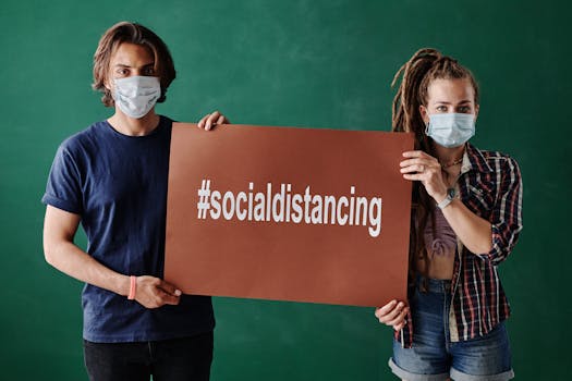 Two People Wearing Face Masks while Holding a Brown Board on Green Background